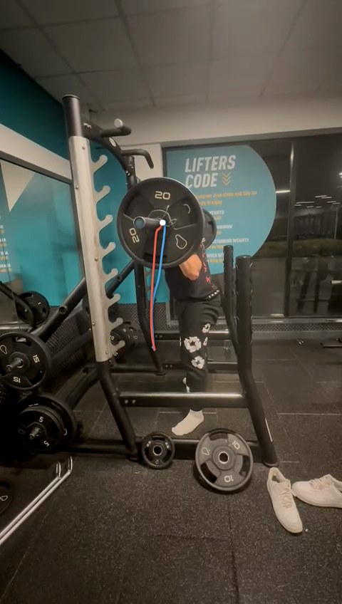 A filmed back squat with the bar's path traced over the plate: blue on the way down, red on the way up